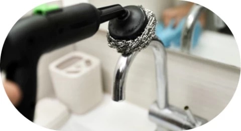 Steam removing limescale from faucet